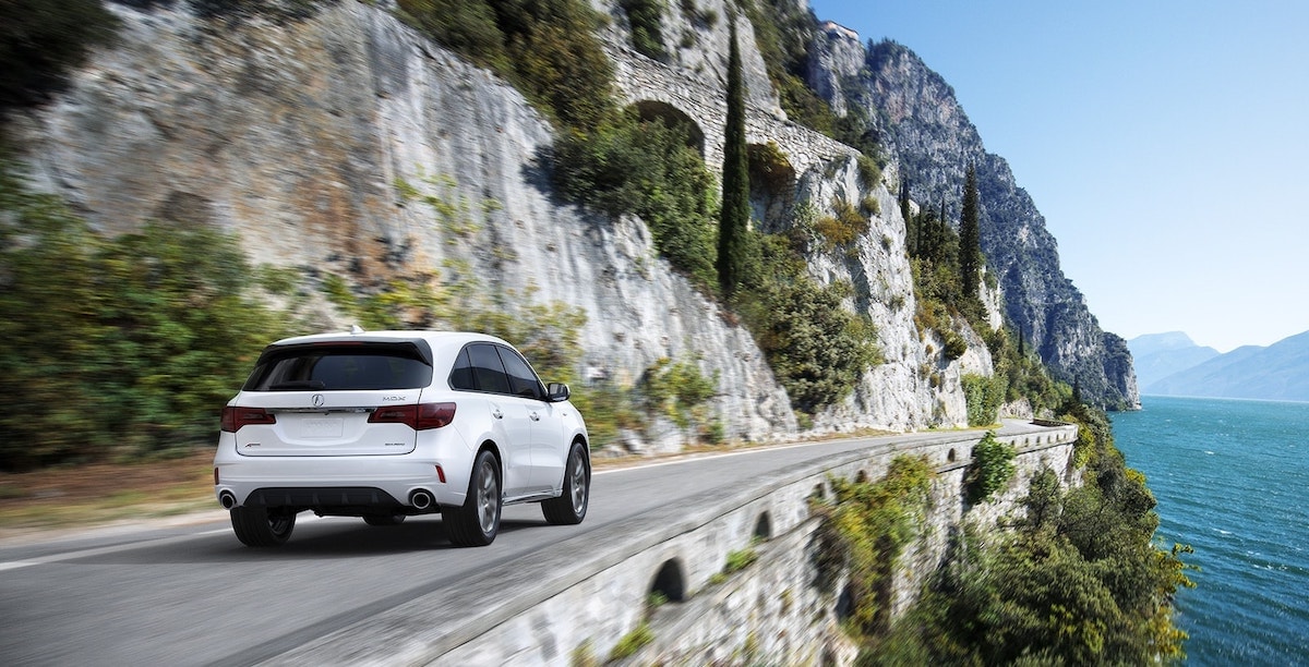 Acura MDX dirving away down the road