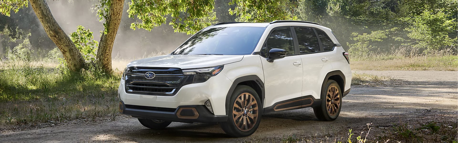 2025 Subaru Forester in white parking outdoor trees in background