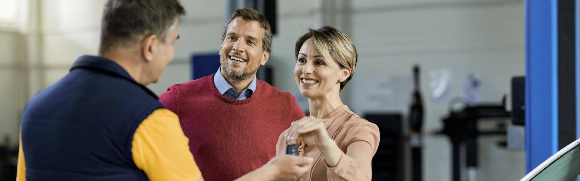 couple receiving vehicle key from agent