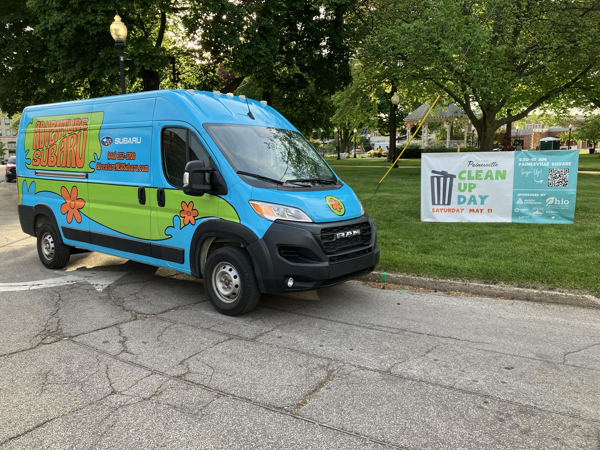 Adventure Subaru's wrapped community van parked beside a Painesville Clean Up Day sign.