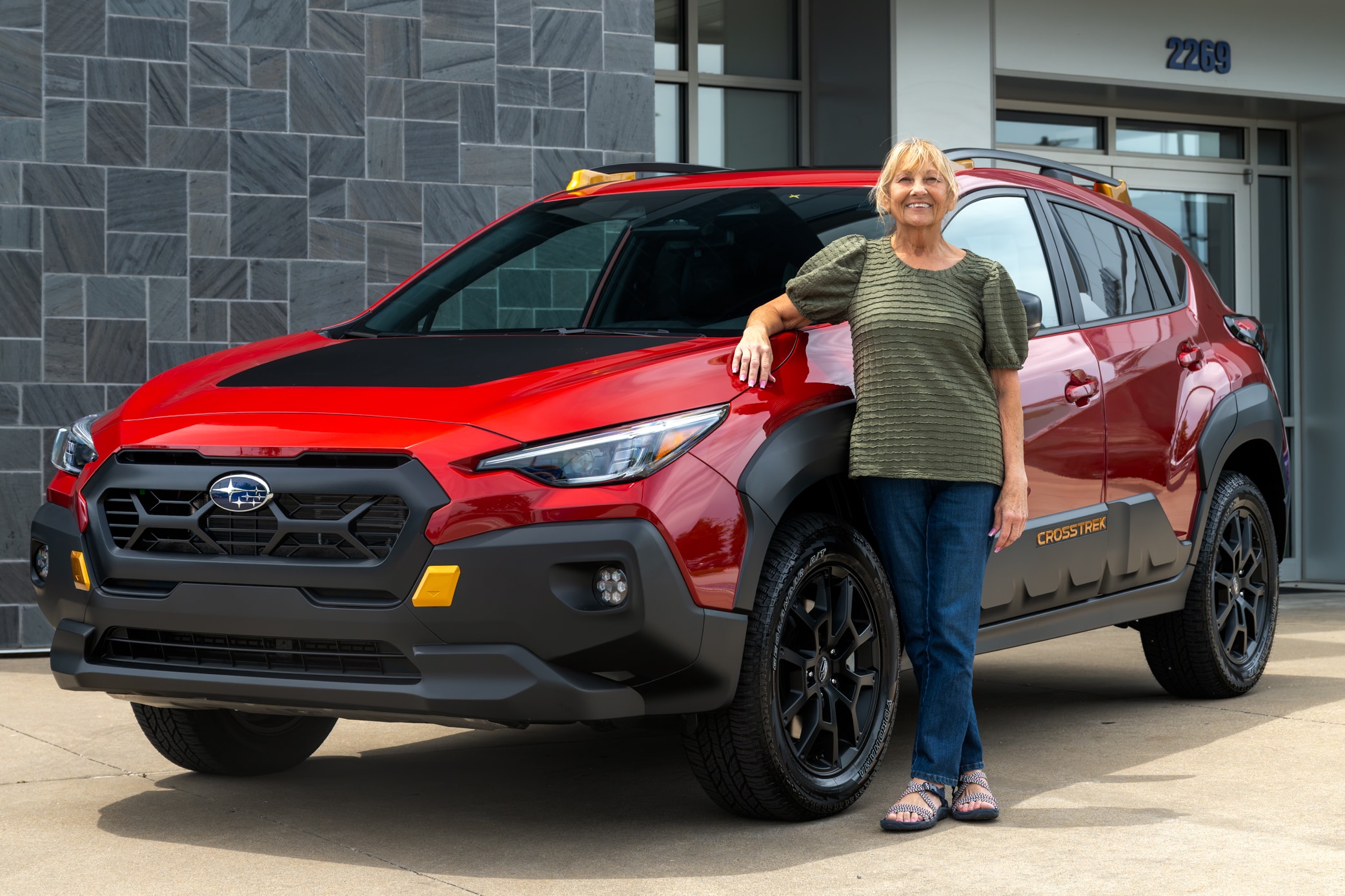 Customer posing with her new Subaru Crosstrek at Adventure Subaru in Fayetteville, AR