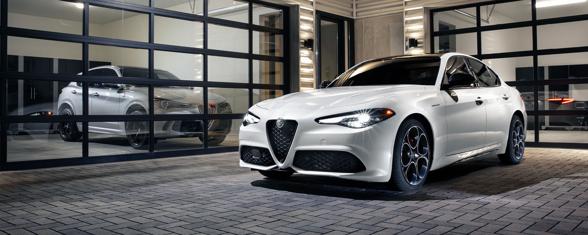 Alfa Romeo cars next to a garage door
