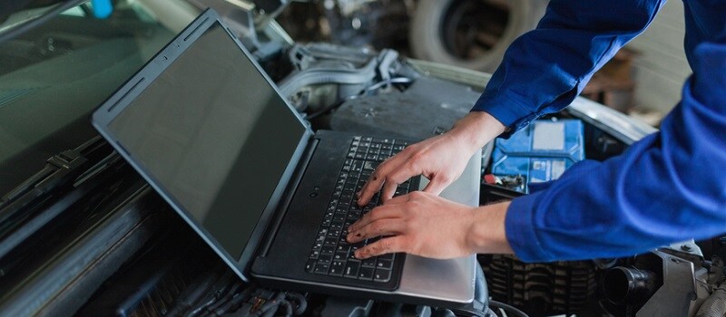 Auto mechanic using laptop