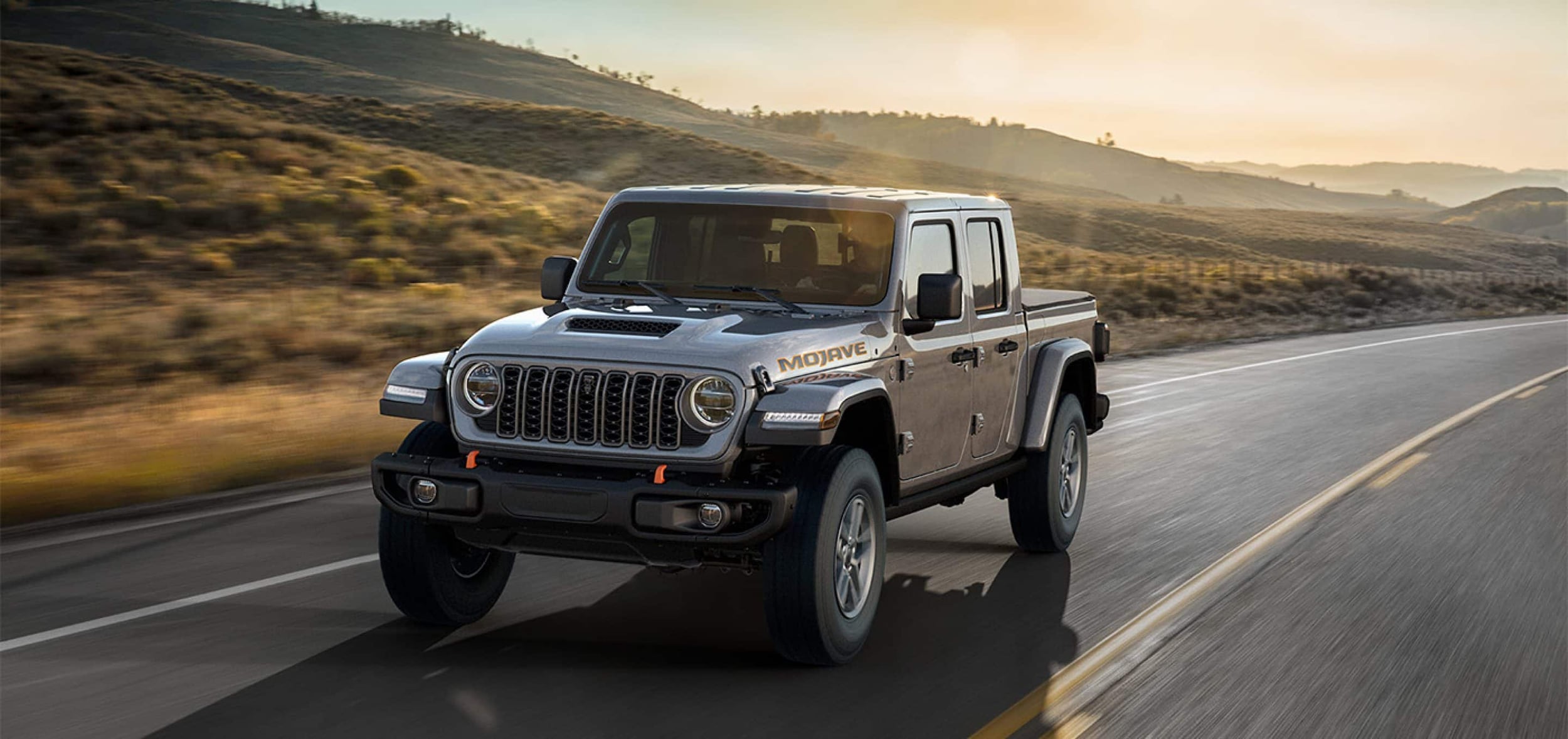 2025-Jeep-Gladiator-Exterior-1.jpg Jeep Gladiator driving on express at sunset.