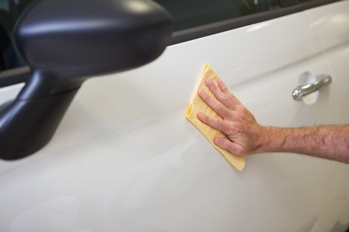 Cleaning side of vehicle as part of Jeep maintenance