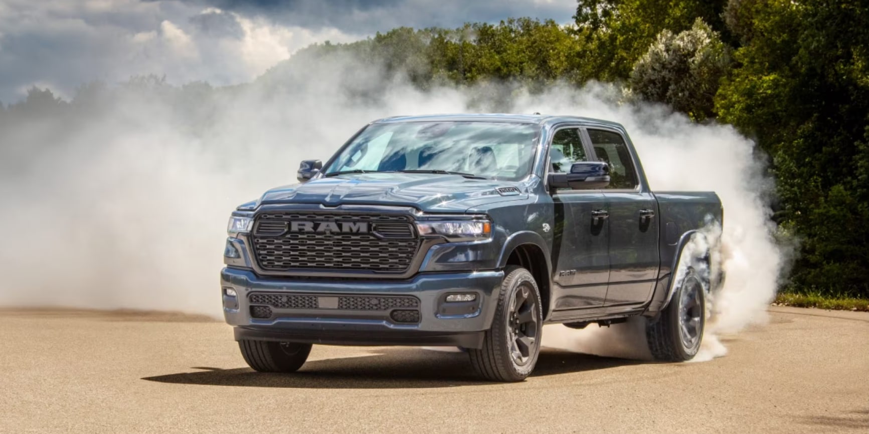 Blue 2026 RAM 1500 performing burnout on pavement.