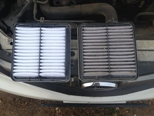 new car air filter next to a dirty car air filter.jpeg
