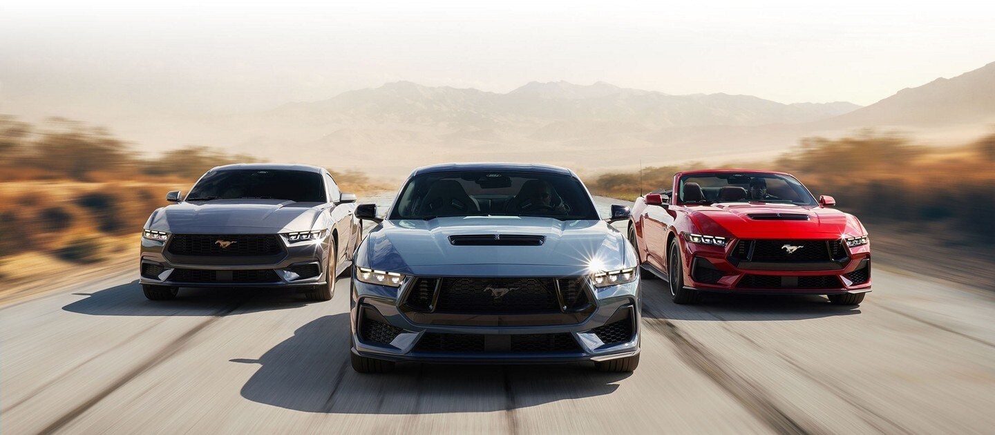 Line up of three different 2023 Ford Mustangs driving down a road