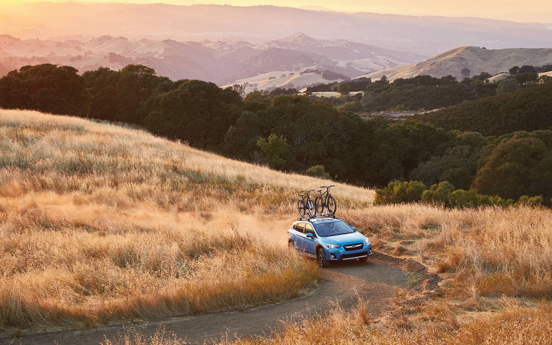Subaru Crosstrek Hybrid driving offroad with bikes on the roof
