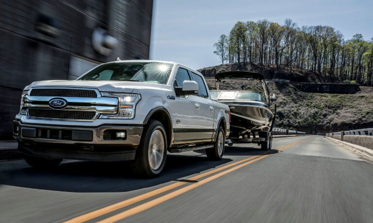 2019 Ford F-150 towing boat through a city