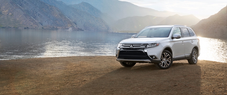 LE 2.4 vs. SEL 2.4 A Mitsubishi Outlander parked by a lake