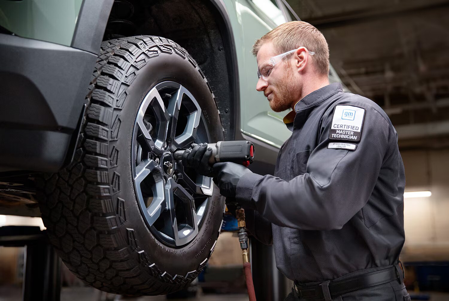  a chevy service team member fixing a tire of a chevy vehicle