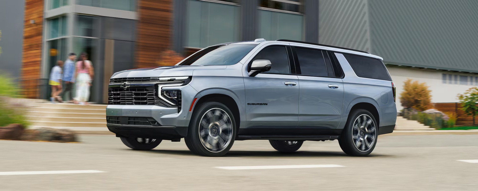 A gray tahoe driving on the road.