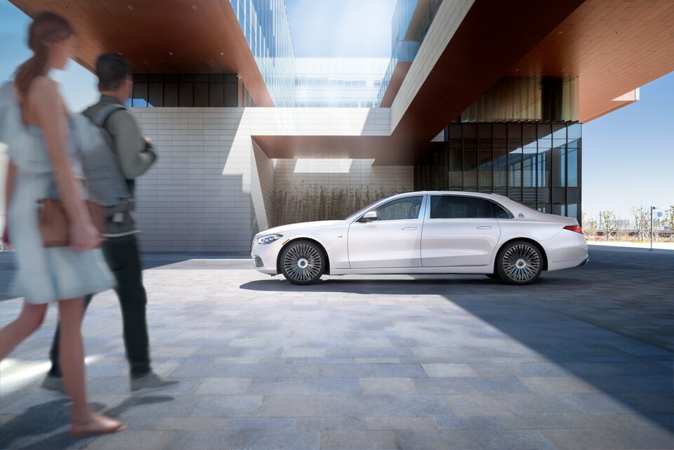 Couple walking past white car.