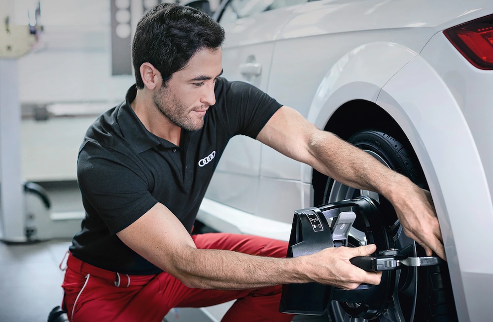  Technician performing routine maintenance on Audi tires