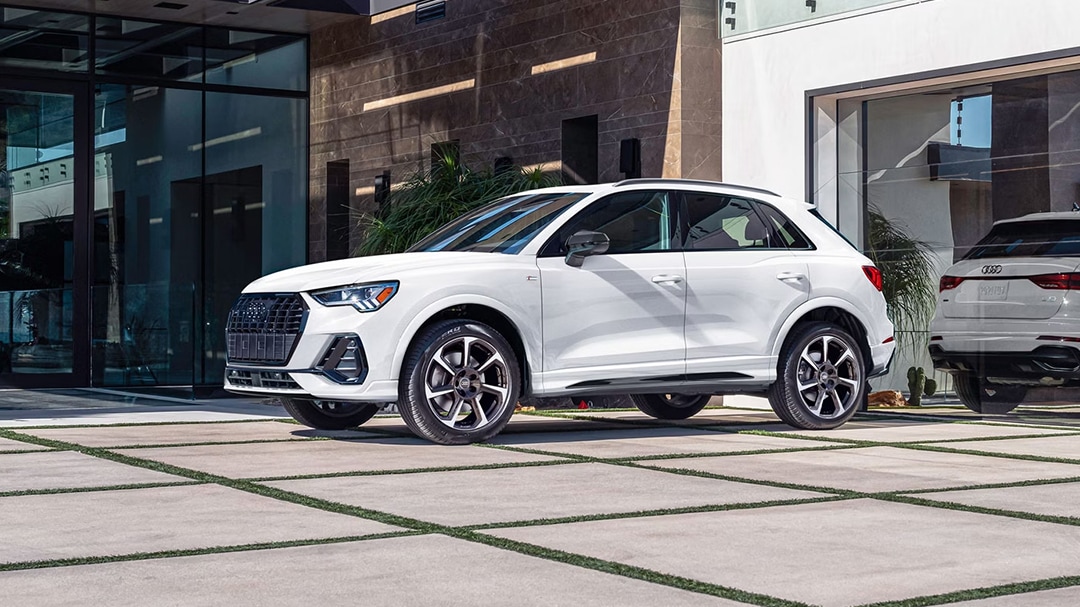 3/4 front and side view of Audi Q3 2025, parked in front of luxury home
