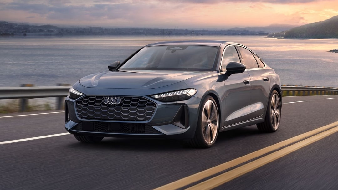 Vue 3/4 avant et latérale de l'Audi A5 2025 sur route en pleine puissance avec vu sur mer en arrière