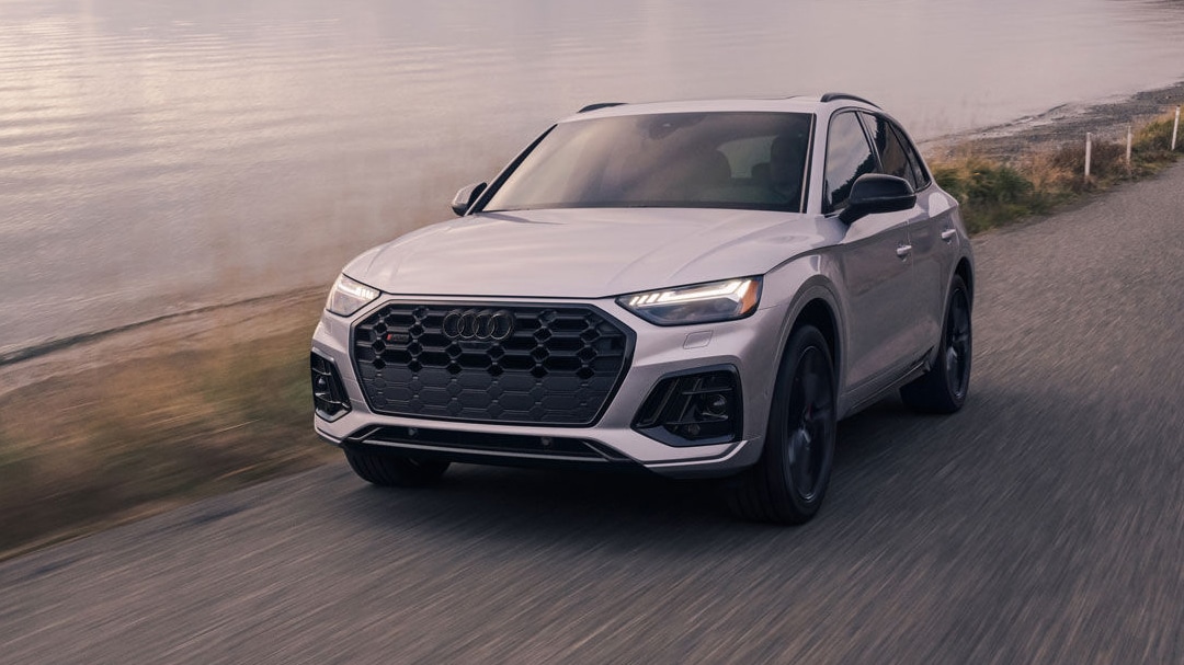3/4 front and side view of the Audi SQ5 2025 on a sandy seaside road