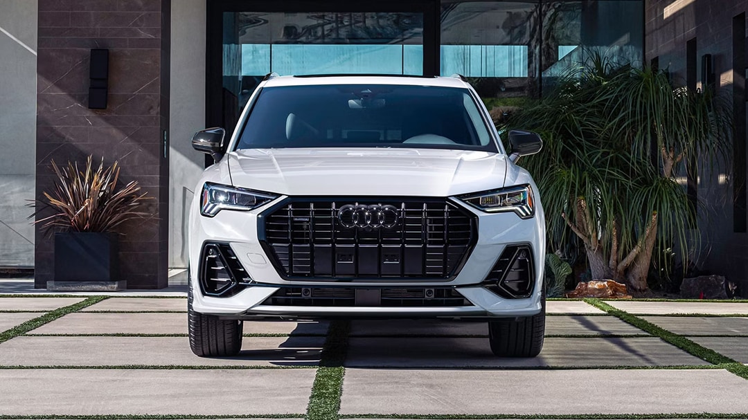 3/4 front view of Audi Q3 2025 parked in front of luxury building
