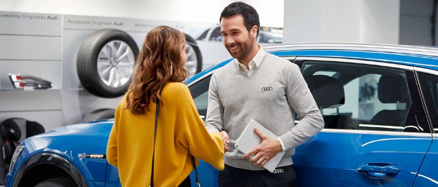 Cliente Audi à sa voiture avec un préposé au service Audi