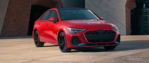 Red Audi sedan parked, front three-quarter view