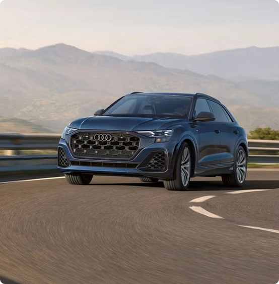 Blue Audi Q8 on a mountain road, front three-quarter view