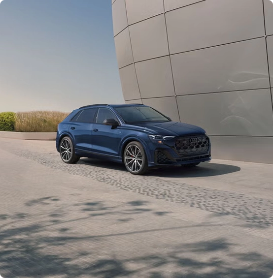 Blue Audi Q8 exterior parked beside a curved building