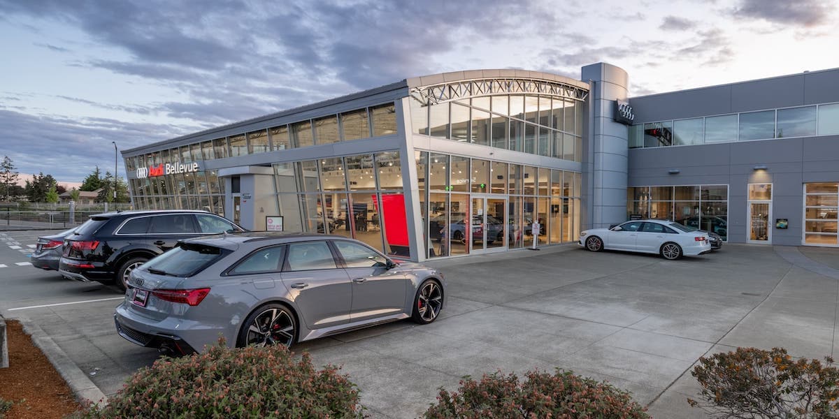 Exterior view of Audi Bellevue in the evening with new Audi vehicles parked out front