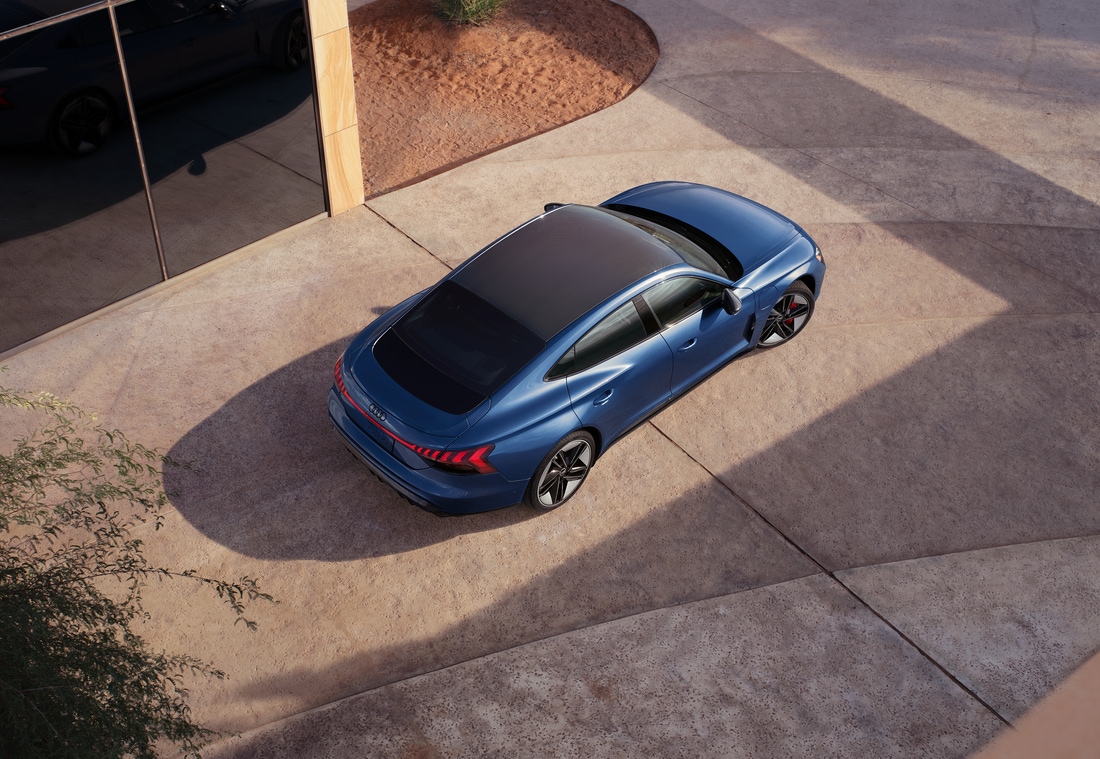 overhead, blue Audi e-tron GT sedan with a black rooftop parked in a driveway