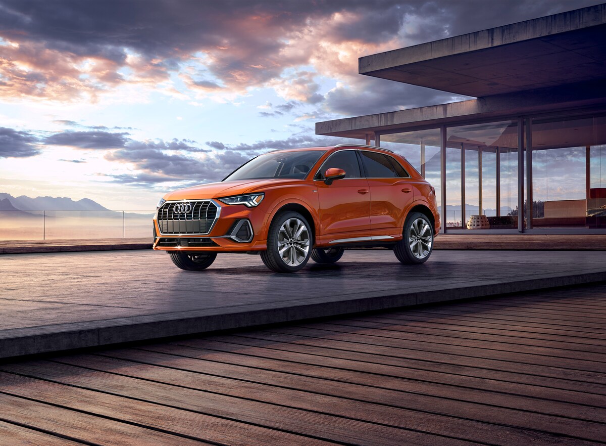 orange Audi Q3 SUV parked in front of a beach house