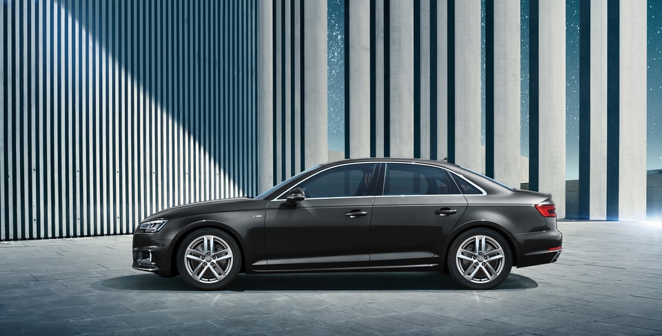 black Audi A4 Premium sedan parked in front of industrial columns