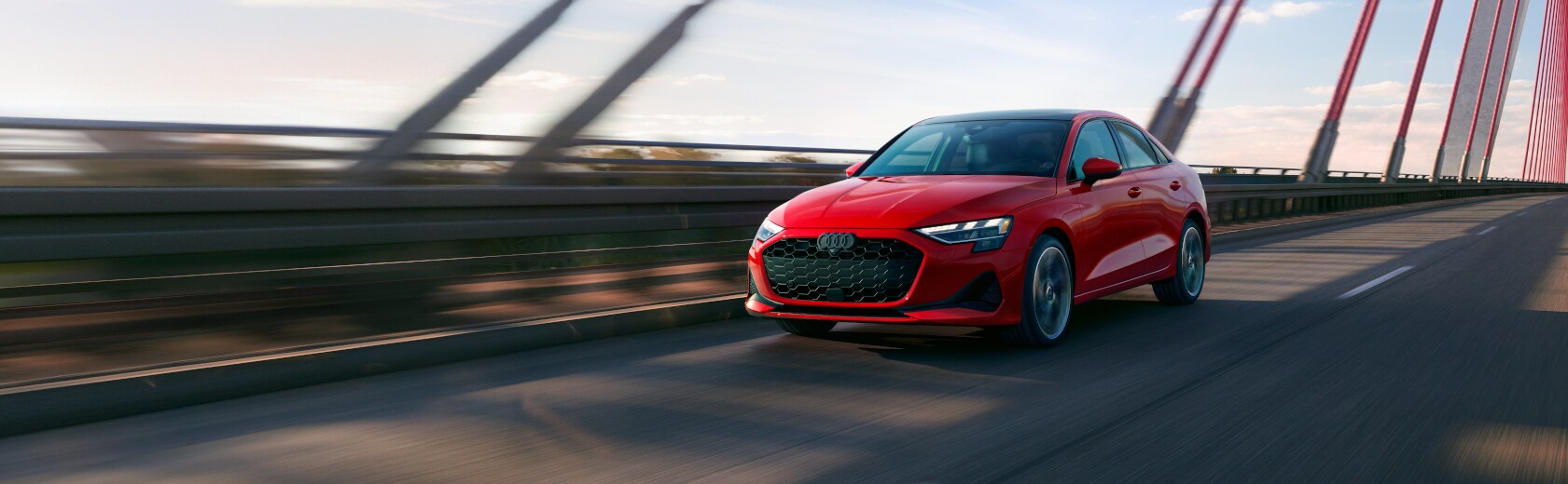 Banner image of a red Audi A3 driving over a bridge