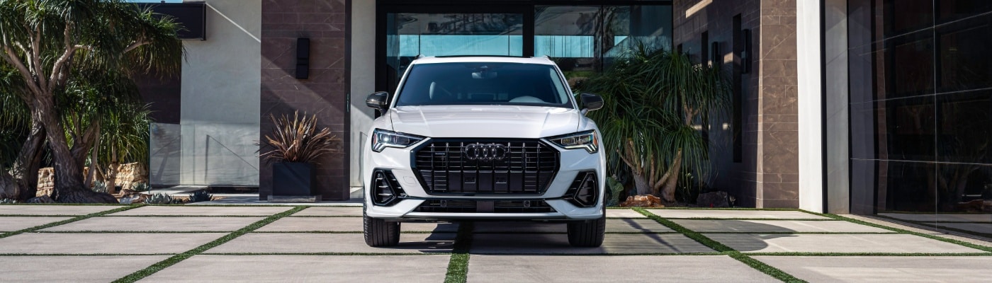 Front grille of an Audi Q3 parked in front of a modern home