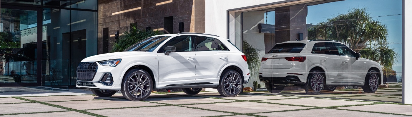 White Audi Q3 S Line parked in front of a modern house
