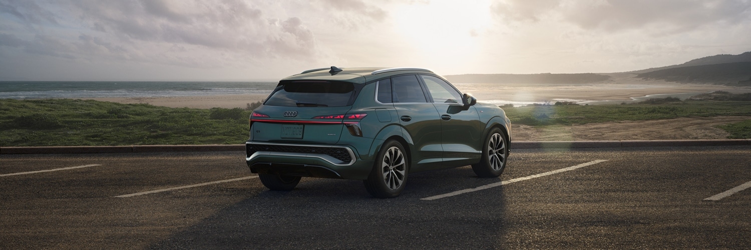 Back side view of Green Audi Q3 parked overlooking the ocean