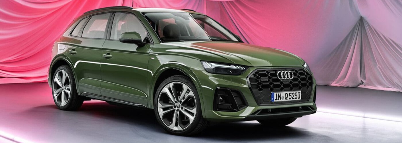 Green 2021 Audi Q5 parked in front of curtain
