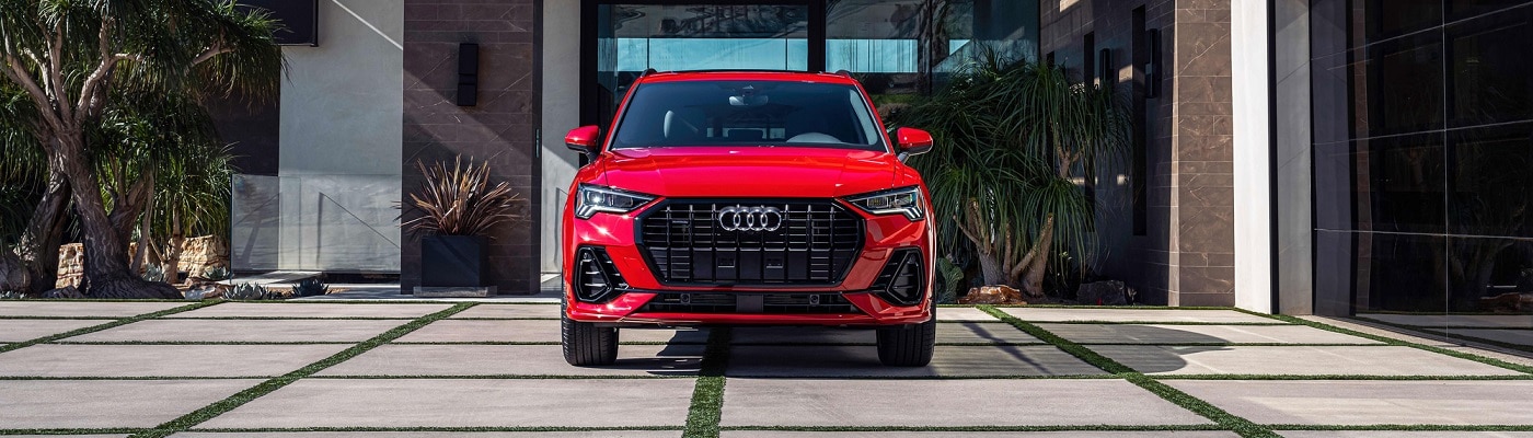 Red Audi Q3 S Line parked in front of a modern house