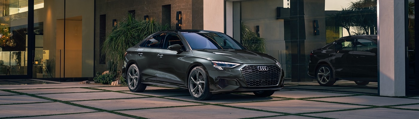 Grey A3 Premium parked in front of a modern house