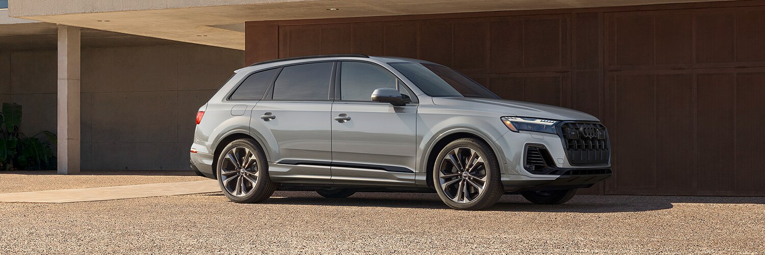 Silver Audi Q7 parked in front of a modern building