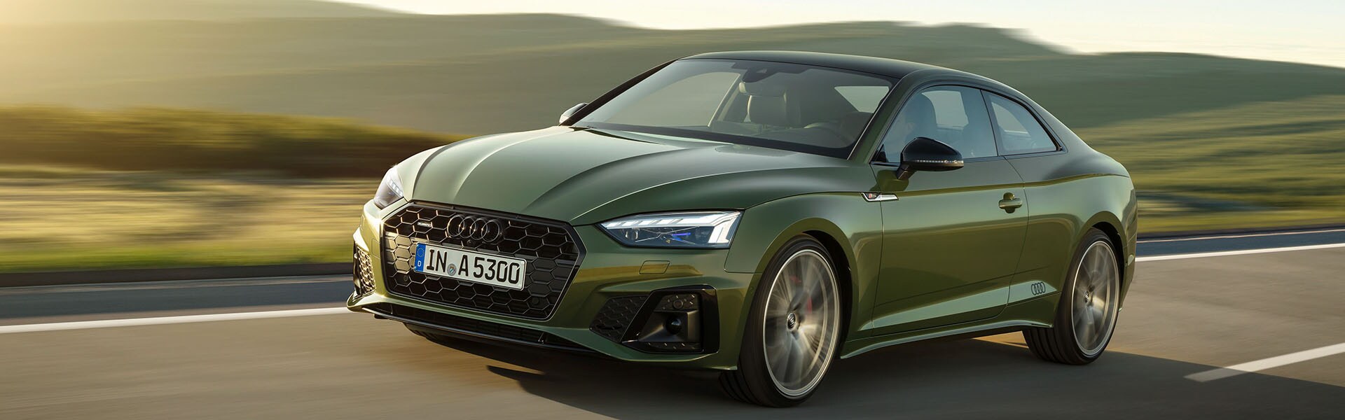 The new 2021 Audi A5 in green drive on country road.