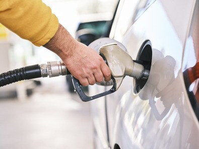 Pumping gas at gas pump. Closeup of man pumping gasoline fuel in car at gas station.