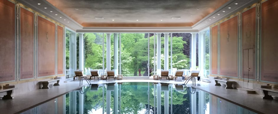 a large indoor swimming pool with a view of the trees