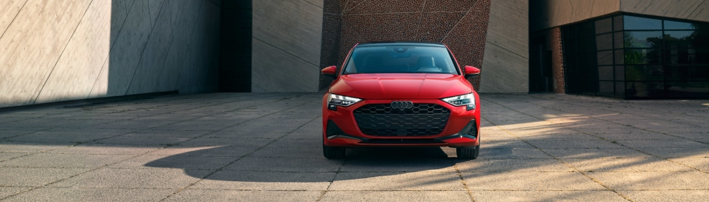 RedAudi A3 Premium parked by a modern building