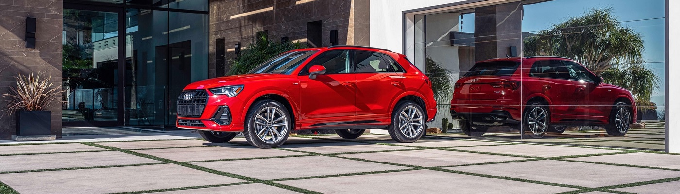 Red Audi Q3 S Line parked in front of a modern house