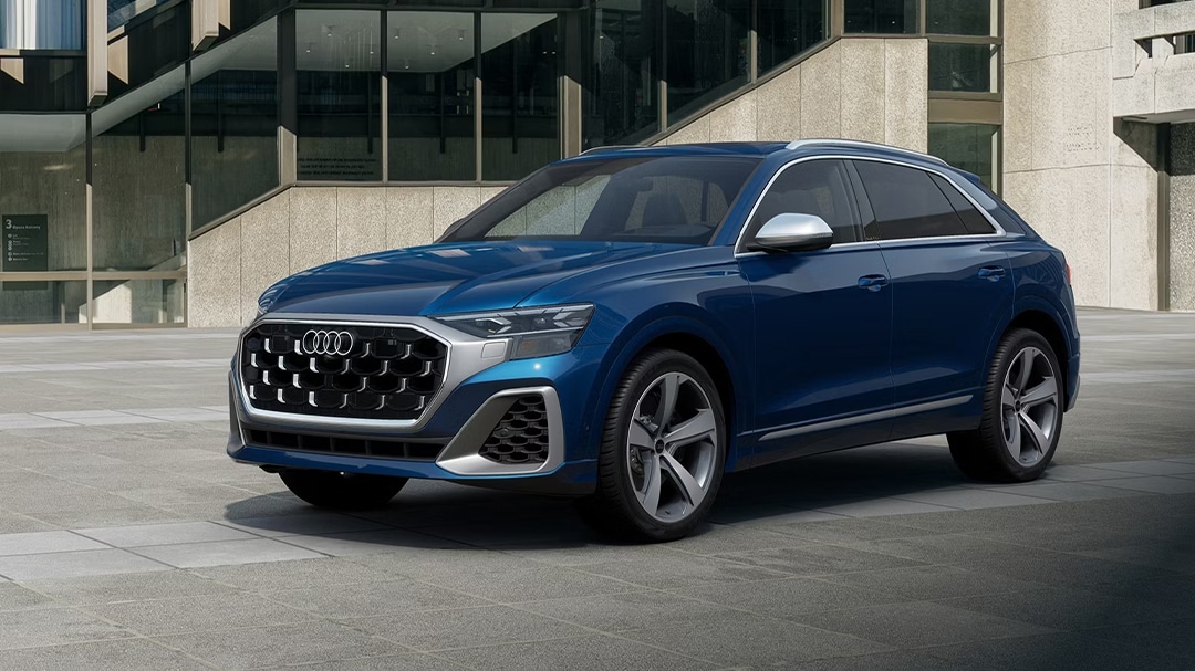 3/4 front and side view of Audi SQ8 parked in front of luxury home