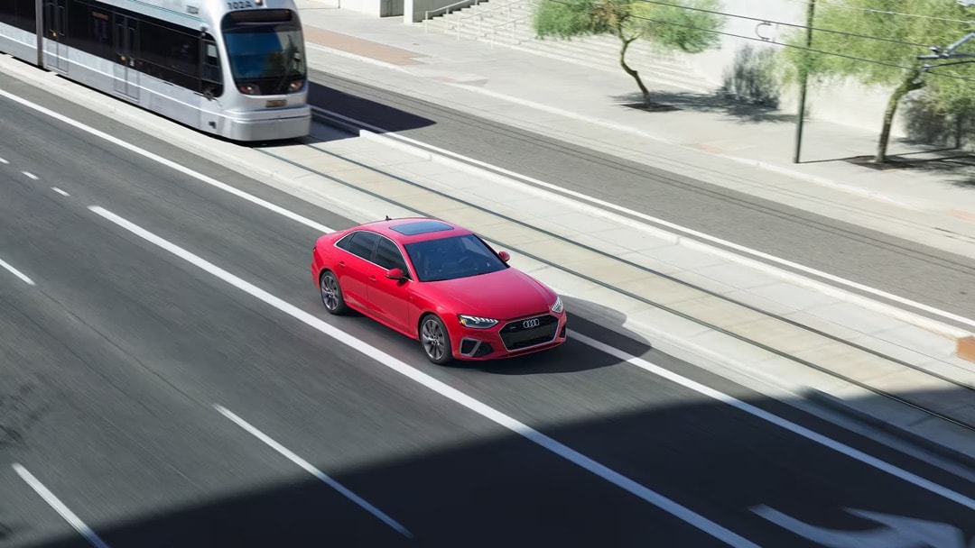 L'Audi A4 2023 rouge roulant sur une route.