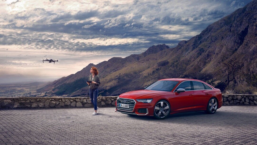 Audi S6 berline 2020 avec une femme utilisant son drone
