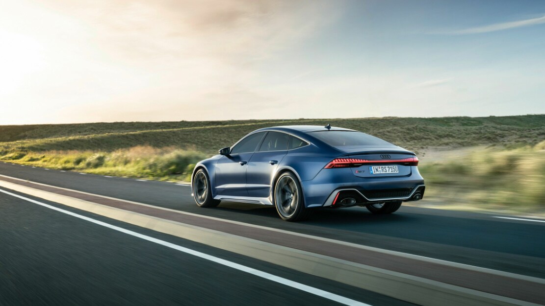 vue latérale arrière d'une Audi RS7 Performance 2023 sur une route de campagne