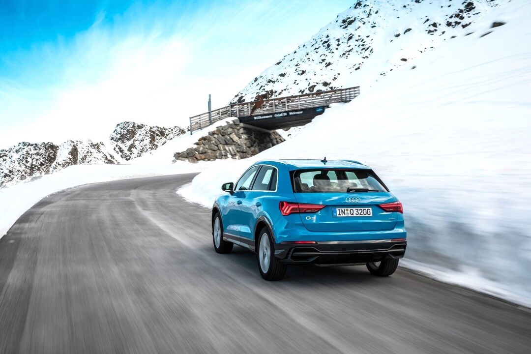 vue 3/4 arrière de l'audi Q3 2019 roulant sur une route pendant la saison hivernale
