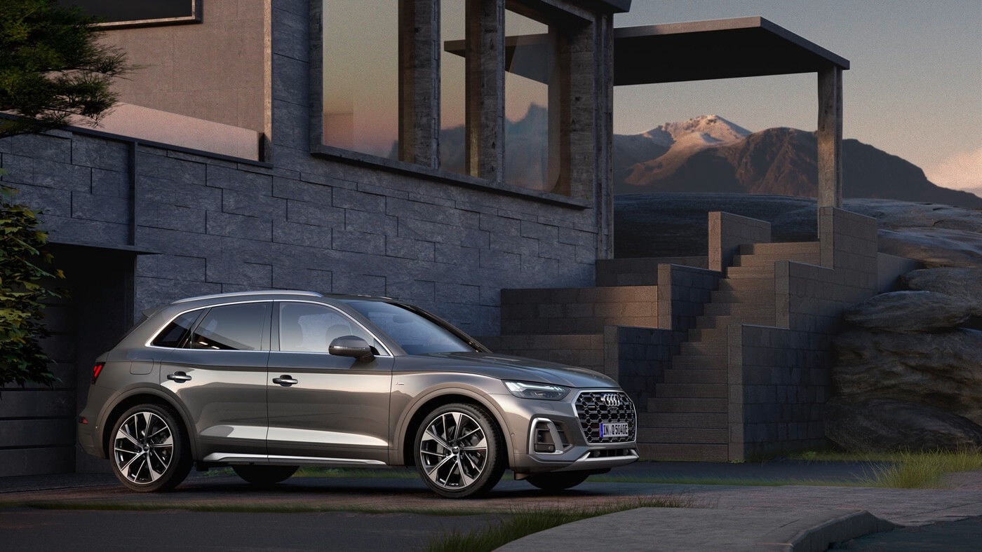 Vue latérale 3/4 avant d'un VUS Audi Q5 TFSI 2022 gris garé à la maison